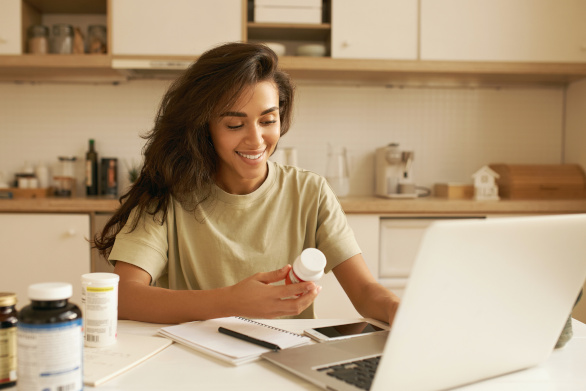 Jeune femme qui choisit son complément multivitaminé